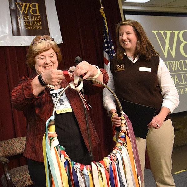 Alumni Holding Ring of Ribbons